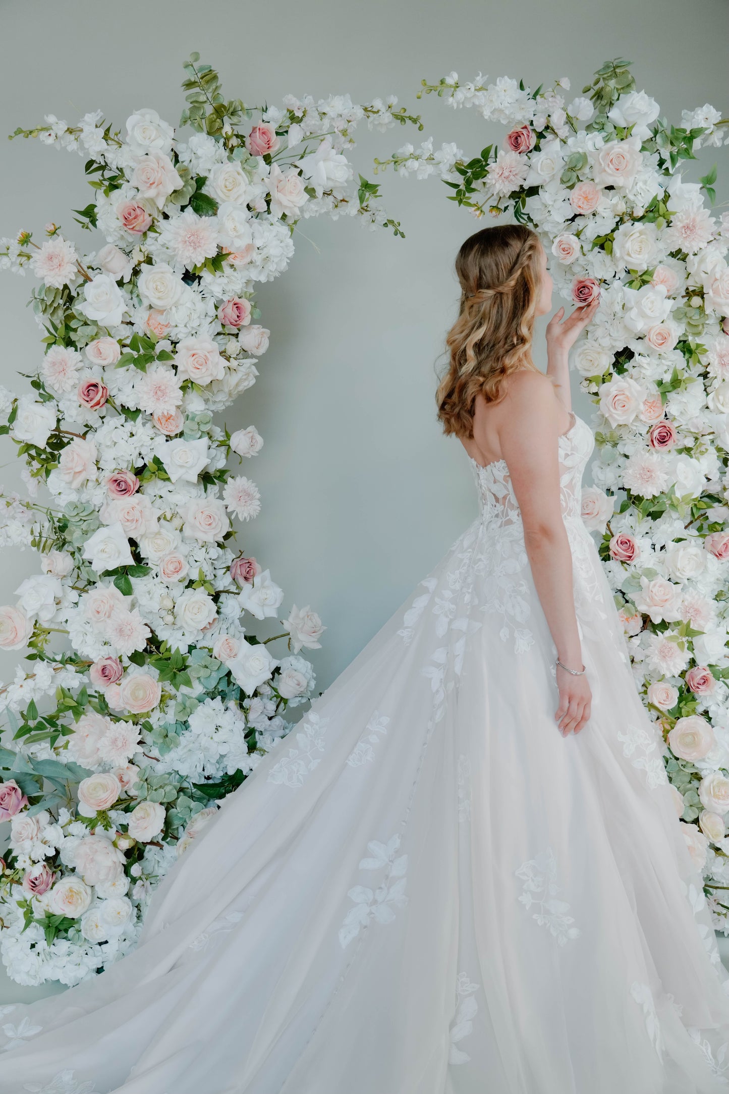 Beautiful Bride Admiring Floral Wedding Arch Rental in Milwaukee Wisconsin